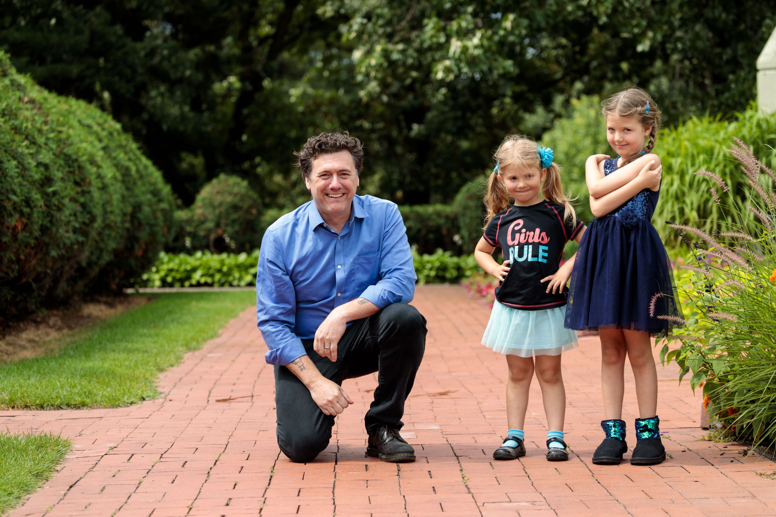 Aric Putnam kneeling to talk with two young girls