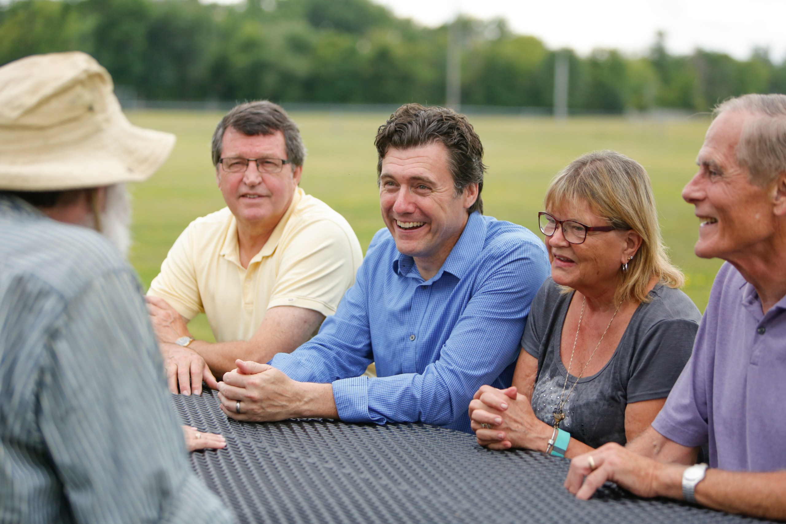 Aric Putnam talking with constituents around a table