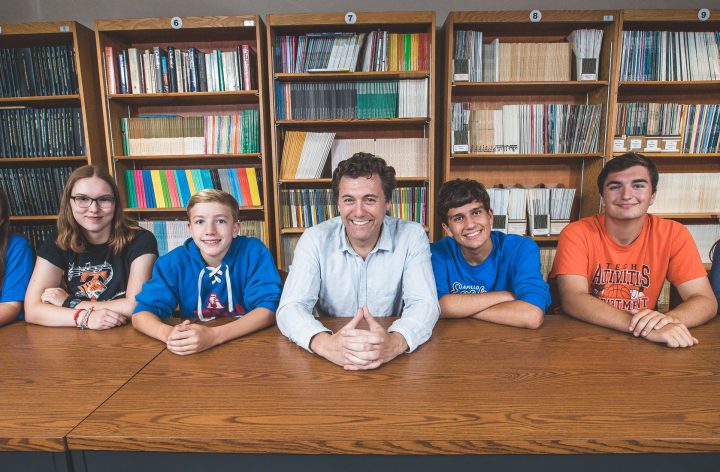 Aric Putnam with students at a table