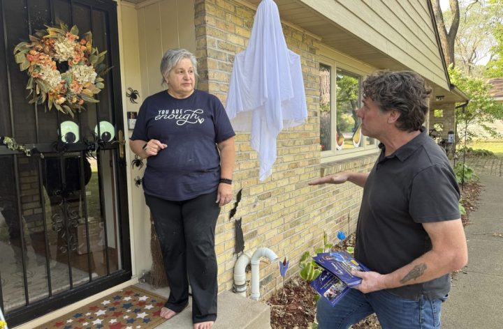 Aric Putnam talking with a St. Cloud resident at her door